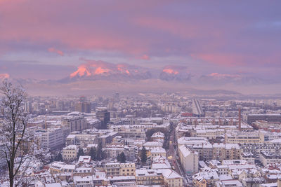 Aerial view of cityscape against cloudy sky