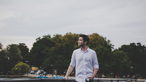 Man standing by river against sky