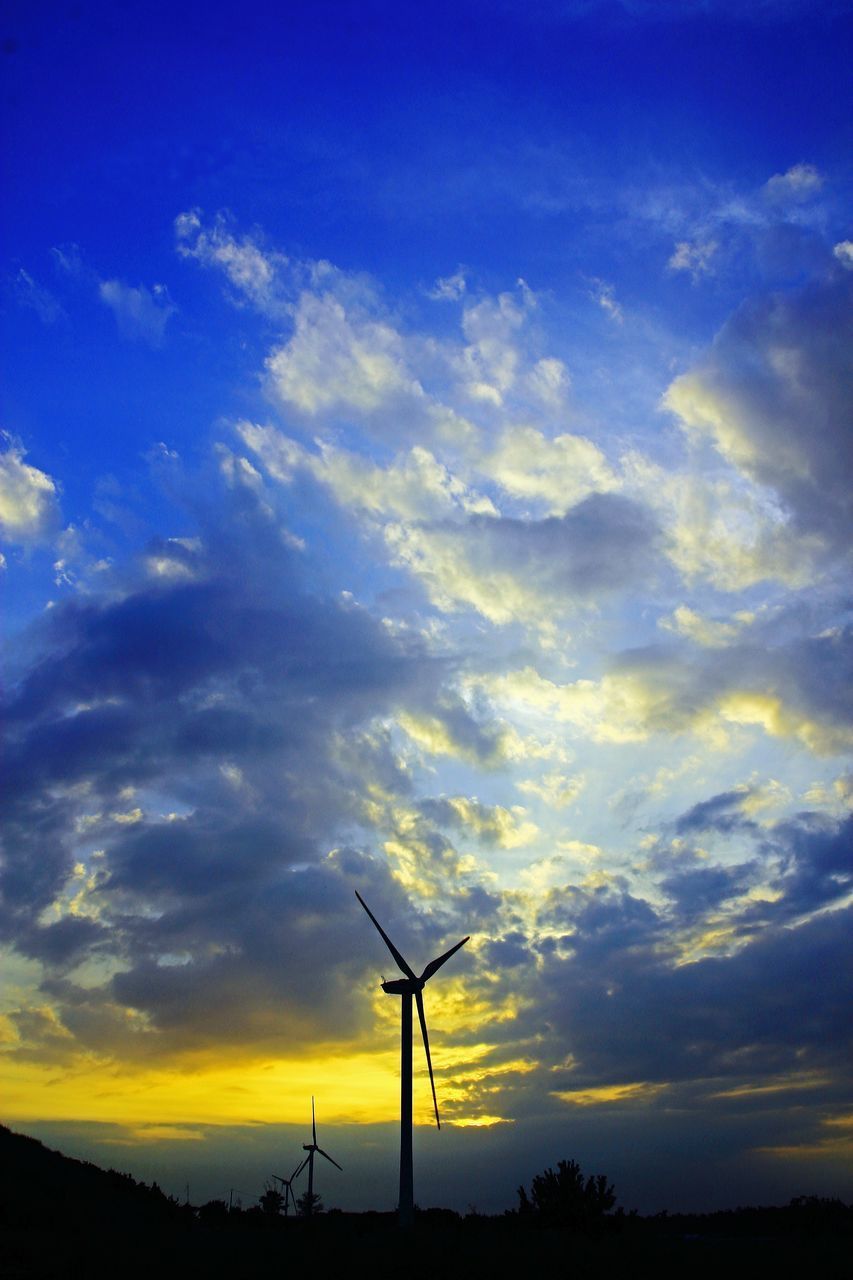 LOW ANGLE VIEW OF WIND TURBINES ON SILHOUETTE LANDSCAPE AGAINST SKY