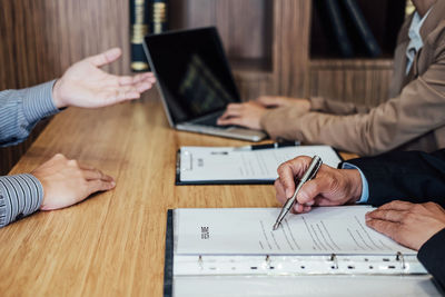 Midsection of managers taking interview on table in office