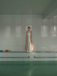 Woman standing by swimming pool