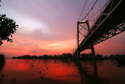 Bridge over river against sky during sunset