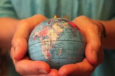 Midsection of woman holding globe