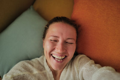 Woman relaxing on the colorful pillows smiling