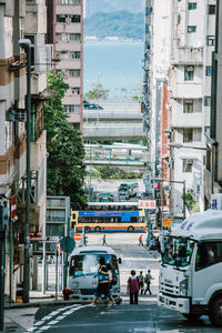 Vehicles on road by buildings in city