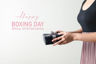 Midsection of woman holding text against white background
