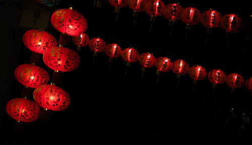 Low angle view of illuminated lanterns hanging at night