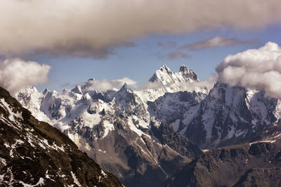 Low angle view of snowcapped mountains against sky