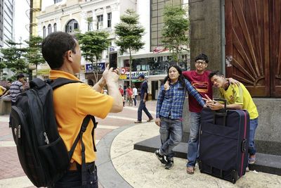 Men standing on sidewalk in city