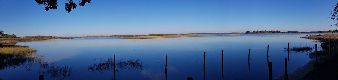 Scenic view of lake against clear blue sky