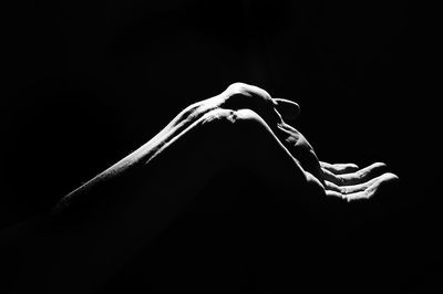 Close-up of woman hand against black background