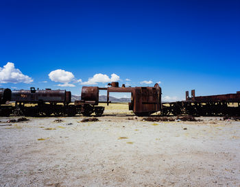 Old train on land against blue sky