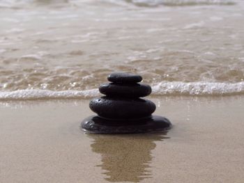 Close-up of stacked pebbles on shore at beach