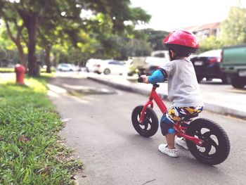 Boy riding bicycle on road