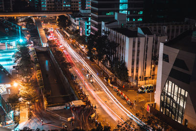 High angle view of illuminated street amidst buildings in city at night