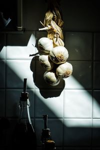 Close-up of garlic hanging on wall at home