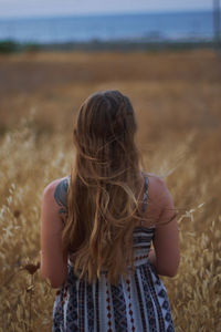 Rear view of woman standing on field