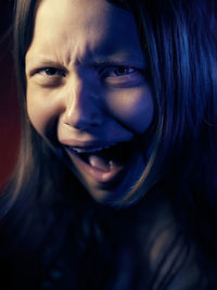 Portrait of young woman screaming at home