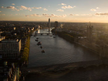 High angle view of river by buildings against sky during sunset