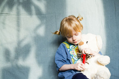 Cute baby girl sitting with toy toys