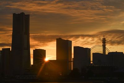 Modern buildings against sky at sunset