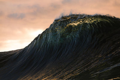 Big wave before crashing under the sunset sky in canary islands