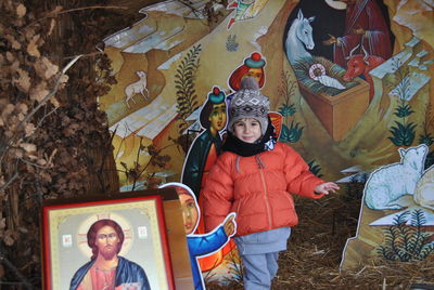 Boy wearing warm clothing while playing at nativity scene