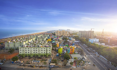 High angle view of city by sea against sky