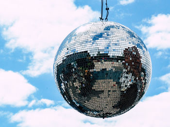 Close-up of disco ball hanging against sky