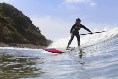 Female sup surfer on a wave