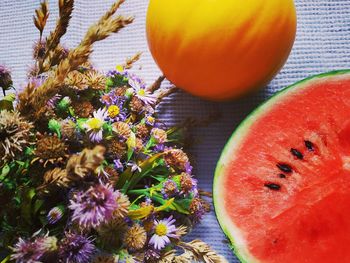 Flowers, watermelon and melon on the table