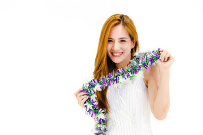 Portrait of a smiling young woman against white background