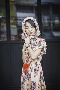 Smiling girl standing against wall