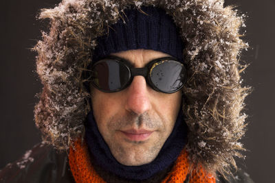 Portrait of man wearing sunglasses against black background