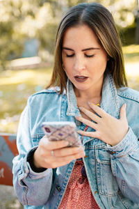 Worried woman using smart phone at park