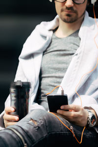 Midsection of man using mobile phone