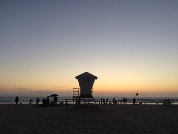 Lifeguard hut at beach against clear sky at dusk