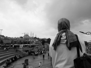 Rear view of people looking at city against sky