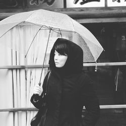 Woman with umbrella in city during monsoon