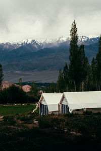 Scenic view of ladakhi landscape, tents and mountains against sky.