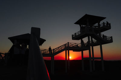 Low angle view of silhouette illuminated against sky at sunset