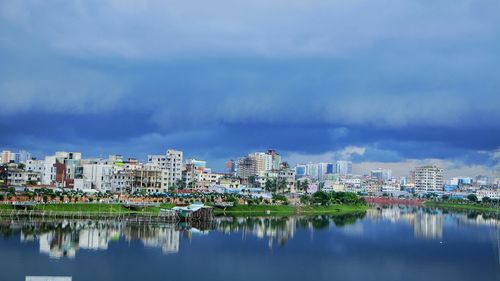 Panoramic view of city by river against sky