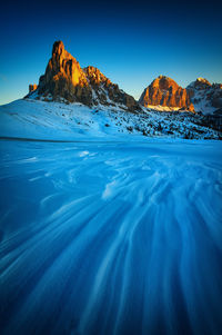 Scenic view of snowcapped mountain against blue sky