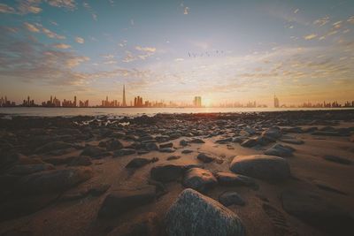 Surface level of beach against sky during sunset