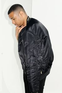 Young man standing against white wall