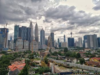 View of buildings in city against cloudy sky