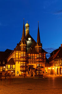 Illuminated building against blue sky at night