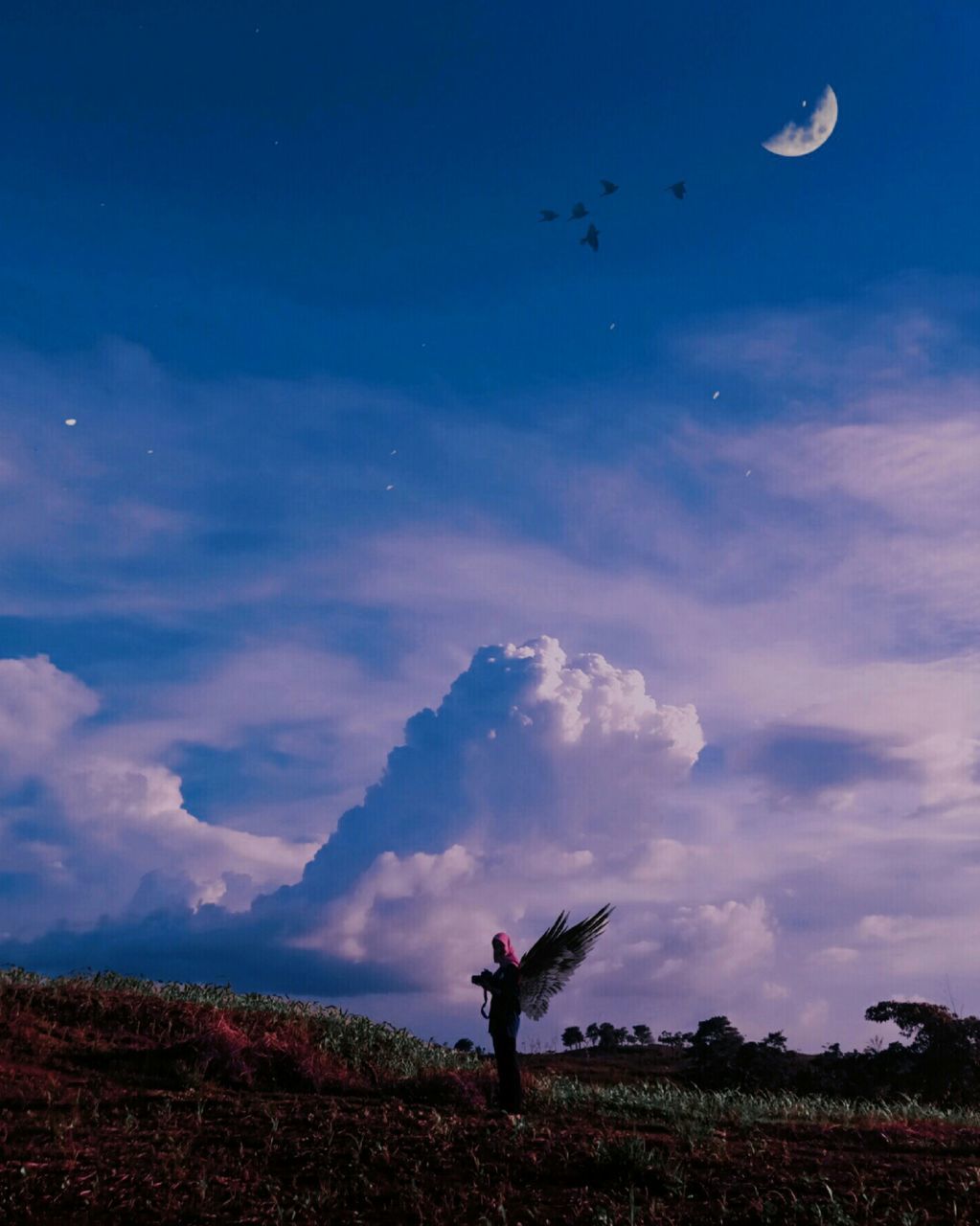 WOMAN STANDING ON FIELD AGAINST BLUE SKY