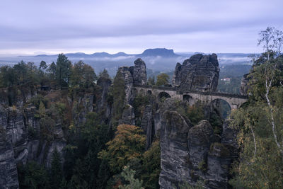 Panoramic view of rocks and trees against sky