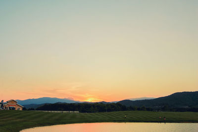 Scenic view of field against clear sky during sunset